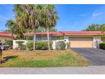 Charming villa showcasing vibrant landscaping, a terra cotta roof, and an attached two-car garage at 6412 Sun Eagle Ln, Bradenton, FL 34210