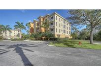 Beautiful building with landscaped grounds, palm trees, and plenty of parking on a sunny day at 6465 Watercrest Way # 404, Lakewood Ranch, FL 34202