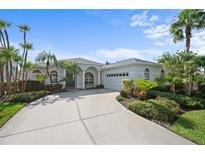 Charming single-story home featuring a well-manicured lawn, mature palm trees, and a two-car garage at 7424 Arrowhead Run, Lakewood Ranch, FL 34202