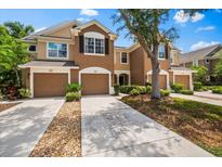 Inviting townhouse featuring a spacious driveway, a two-car garage, and well-maintained landscaping at 8209 72Nd E St, University Park, FL 34201