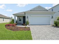Charming single-Gathering home featuring a two-car garage, landscaped yard, and inviting front entrance at 9970 Cross River Trl, Parrish, FL 34219
