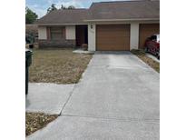 Single story home showing the front door, attached garages, and a front yard with simple landscaping at 1163 Deer Hollow Pl, Sarasota, FL 34232