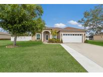 Charming single-story home with a well-manicured lawn, lush landscaping, and an attached two-car garage at 1606 22Nd W Ave, Palmetto, FL 34221