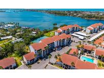 Stunning aerial view of waterfront condos featuring lush landscaping, a pool, and gorgeous water views at 1624 Stickney Point Rd # 204, Sarasota, FL 34231