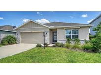 Charming one-story home featuring a stone-accented facade and a well-manicured lawn with lush landscaping at 17119 Barnwood Pl, Bradenton, FL 34211