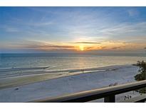 Scenic beachfront view during sunset, with calm ocean waters and a sandy shoreline, perfect for relaxation and recreation at 20 Whispering Sands Dr # 1201, Sarasota, FL 34242