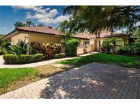 Charming home with lush landscaping, a brick driveway, and a well-maintained lawn at 4812 Kestral Park Cir # 20, Sarasota, FL 34231