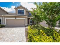 Charming two-story home showcasing a well-manicured lawn and a paved driveway leading to a two-car garage at 5237 Blossom Cv, Lakewood Ranch, FL 34211