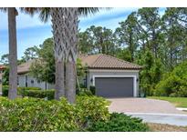 Charming home featuring a tile roof, paved driveway and an attached two car garage at 5301 Bartolomeo St, Sarasota, FL 34238