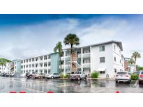 Three story building with parking in front on a partly cloudy day with palm trees and stairwells on the sides at 5877 17Th W St # B4, Bradenton, FL 34207