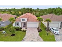 An aerial view of a charming single-story home with a terracotta tile roof and manicured landscaping at 620 Nasturtium Ct, Nokomis, FL 34275