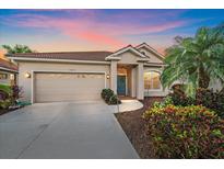 Charming single-story home with lush landscaping and a well-maintained front yard and a two-car garage at 6408 Rookery Cir, Bradenton, FL 34203