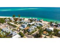Beautiful aerial view of beachfront property with lush landscaping and turquoise water at 802 N Bay Blvd, Anna Maria, FL 34216