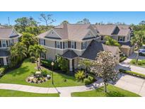 Beautifully landscaped home with a manicured lawn, palm trees, and lush plantings at 8073 Tybee Ct, University Park, FL 34201