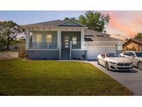 Charming home with a manicured lawn and a stylish two-car garage with vehicles parked out front at 8622 Inwood Dr, Hudson, FL 34667