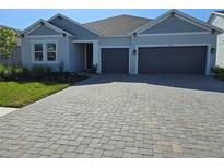 Charming single-story home featuring a paved driveway and a two-car garage at 1591 Laurel Brook Ln, Port Charlotte, FL 33953