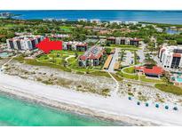Breathtaking aerial view of beachfront condos with lush landscaping and pristine beach access, perfect for coastal living at 2045 Gulf Of Mexico Dr # M1-207, Longboat Key, FL 34228