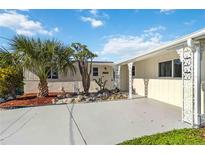 Charming single-story home featuring white exterior, decorative pillars, xeriscaping, and well-maintained landscaping at 21152 Higgs Dr, Port Charlotte, FL 33952