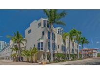 Stunning condo building featuring multiple floors and a corner facade, surrounded by lush palm trees at 235 Cocoanut Ave # 108B, Sarasota, FL 34236