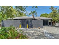 Contemporary home featuring a textured gray exterior, white tile roof, and stylish yellow decor at 4857 Stevens Dr, Sarasota, FL 34234