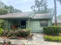 Charming single-story home with a light green exterior, front porch, and well-maintained landscaping at 5014 Barrington Cir # 2102, Sarasota, FL 34234