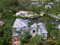 Stunning aerial view of luxury waterfront home with boat dock nestled among lush greenery and canal access at 5132 Jungle Plum Rd, Sarasota, FL 34242