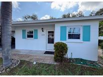 Charming single-story home featuring a well-maintained yard and bright blue window shutters at 6074 Arlene Way # 5, Bradenton, FL 34207