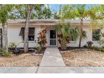 Charming front entrance with a tiled walkway, lush landscaping, and a light colored exterior at 642 N Jefferson Ave # 13, Sarasota, FL 34237