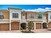 Attractive townhouse showcases an attached garage, well maintained landscaping, and tan and white exterior paint at 7346 Skybird Rd # 417, Bradenton, FL 34209