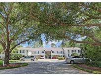 Exterior shot of the townhomes featuring mature landscaping and a well-maintained parking area at 802 Montrose Dr # 204, Venice, FL 34293