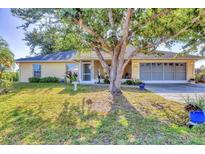 Charming single-story home with a well-manicured lawn and mature tree in a quiet residential neighborhood at 9366 Westminster Ave, Englewood, FL 34224