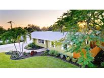 Charming single-story home with a well-manicured lawn and mature tropical landscaping at 1010 68Th Nw St, Bradenton, FL 34209