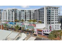 Modern condo building featuring a rooftop pool, colorful murals, and stylish architecture at 111 S Pineapple Ave # 813, Sarasota, FL 34236