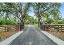 Long private driveway with gate and beautiful mature shade trees leading to the home at 140 Cowpen Ln, Sarasota, FL 34240
