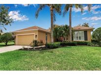 Charming single-story home features a lush lawn, mature landscaping, and a two-car garage at 1542 Ormond Ter, Parrish, FL 34219