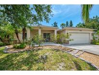 Beautiful single-Gathering home with well-manicured landscaping, a two-car garage, and a cozy front porch at 1715 Fossil Dr, Englewood, FL 34223