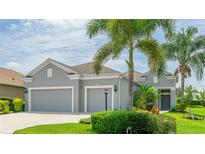 Charming home featuring a well-manicured lawn, mature landscaping and a three-car garage at 2240 Crystal Lake Trl, Bradenton, FL 34211