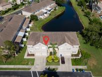 Aerial view of a two-story townhome with attached garage, water view, and manicured landscaping at 4103 Foristall Ave # 4103, Sarasota, FL 34233