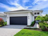 Beautiful single-story home featuring a well-maintained lawn, a two-car garage, and lush landscaping at 4927 Carova Way, Bradenton, FL 34211
