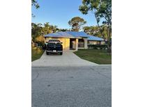 Charming single-story home featuring a metal roof, a long driveway and manicured landscaping at 5530 21St Street E Ct, Bradenton, FL 34203