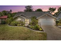 Charming single-story home with a well-manicured lawn, a two car garage and lush tropical landscaping at 5750 Carriage Dr, Sarasota, FL 34243