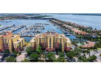 Aerial view showcases waterfront condos with marina, beautiful landscaping, and water views at 610 Riviera Dunes Way # 308, Palmetto, FL 34221