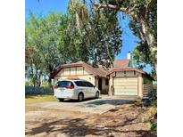 Charming single-story home with a well-maintained lawn and a private driveway with a white van at 6265 Viola Ln, New Port Richey, FL 34653