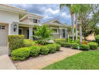 Beautifully landscaped front yard with lush greenery and a brick walkway leading to the home at 6470 Indigo Bunting Pl, Lakewood Ranch, FL 34202