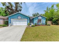 Charming blue home with a well-manicured lawn and a white two-car garage at 7810 34Th E Ct, Sarasota, FL 34243