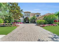 Stunning home featuring a grand entrance, lush landscaping, and a circular driveway at 8105 Warwick Gardens Ln, University Park, FL 34201