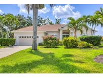 Landscaped front yard of home with lush green lawn and beautiful tropical plants creates curb appeal at 8604 15Th Nw Ave, Bradenton, FL 34209