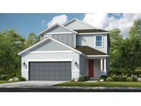 Charming two-story home with gray siding, a two-car garage and a well-manicured lawn at 8633 Snowfall St, Sarasota, FL 34241