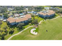 An aerial view of a residential complex, tennis court, pool, water feature, and golf course at 9620 Club South Cir # 5304, Sarasota, FL 34238