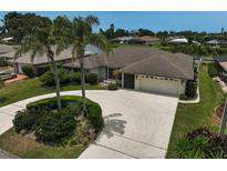 Single-story home boasting an attached two-car garage, circular driveway, and well-manicured landscaping at 1227 Waterside Ln, Venice, FL 34285